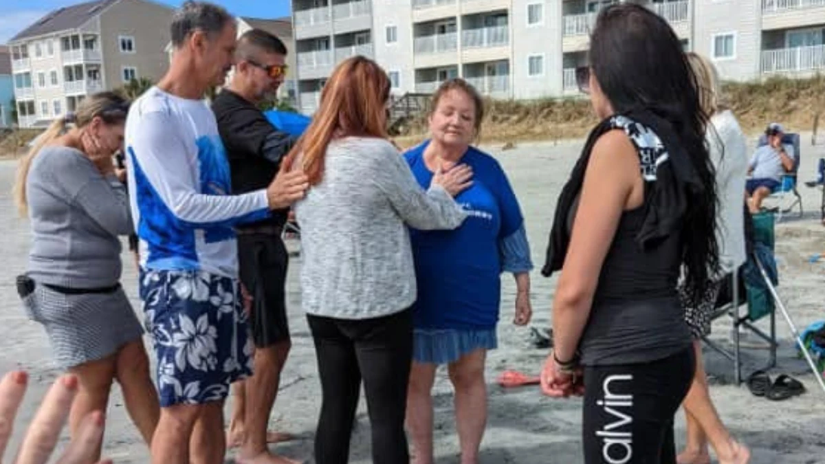 Members of THAT Church praying together outside